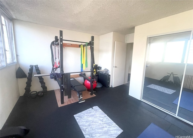 exercise room with a textured ceiling and a wealth of natural light