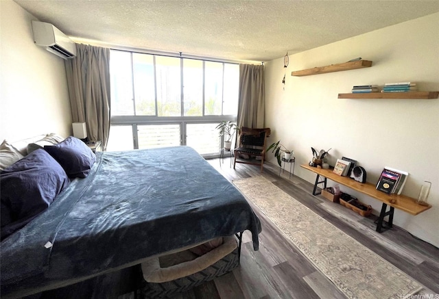 500 University Ave Unit 704, Honolulu, HI 96826 - bedroom featuring an AC wall unit, a textured ceiling, wood finished floors, and expansive windows