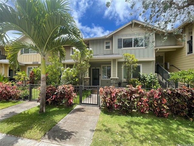 91-960 Iwikuamoo St Unit 304, Ewa Beach, HI 96706 - view of front of home featuring board and batten siding, fence, a gate, and stone siding