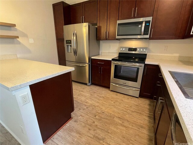kitchen featuring open shelves, dark brown cabinetry, stainless steel appliances, a peninsula, and light wood-type flooring