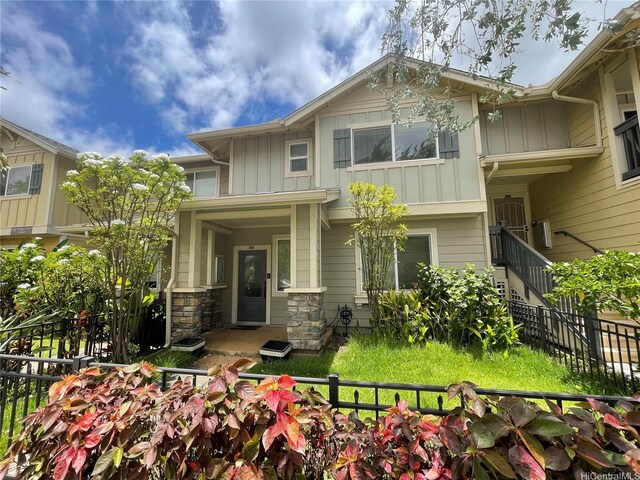 91-960 Iwikuamoo St Unit 304, Ewa Beach, HI 96706 - view of front of property featuring board and batten siding, fence, and stone siding