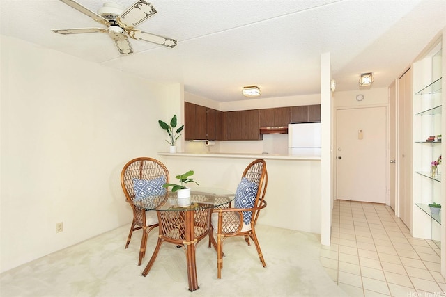 dining area with ceiling fan and light colored carpet