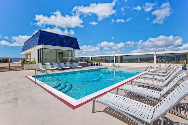community pool with a patio and fence