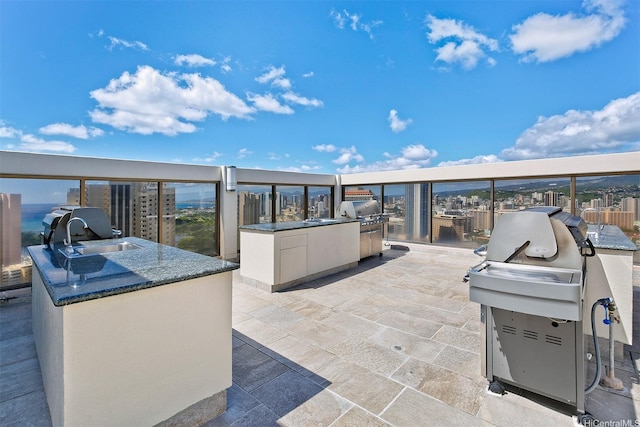 view of patio with exterior kitchen, area for grilling, and a sink