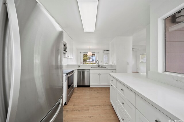 94-831 Lumiauau St Unit H104, Waipahu, HI 96797 - kitchen with a sink, light wood finished floors, appliances with stainless steel finishes, and white cabinets