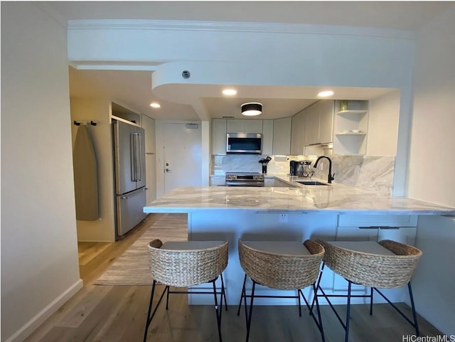 1777 Ala Moana Blvd Unit 901, Honolulu, HI 96815 - kitchen with backsplash, appliances with stainless steel finishes, open shelves, a sink, and a peninsula