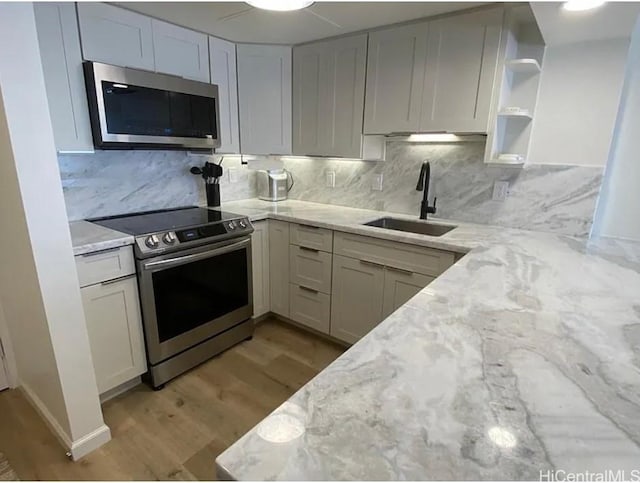1777 Ala Moana Blvd Unit 901, Honolulu, HI 96815 - kitchen with open shelves, a sink, light stone counters, light wood-style floors, and stainless steel appliances