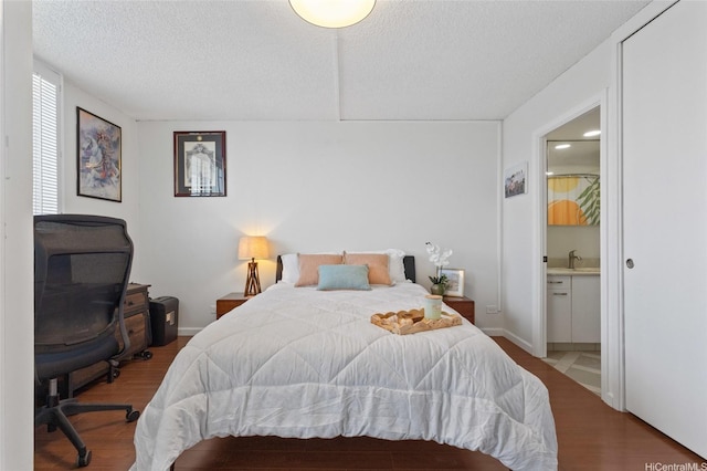927 Prospect St Unit 604, Honolulu, HI 96822 - bedroom featuring a textured ceiling, connected bathroom, and wood finished floors