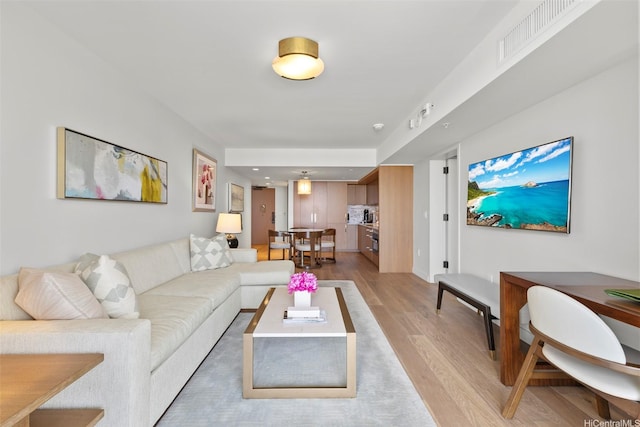 living room featuring light wood finished floors and visible vents