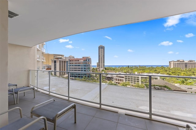 balcony featuring a view of city, a water view, and visible vents