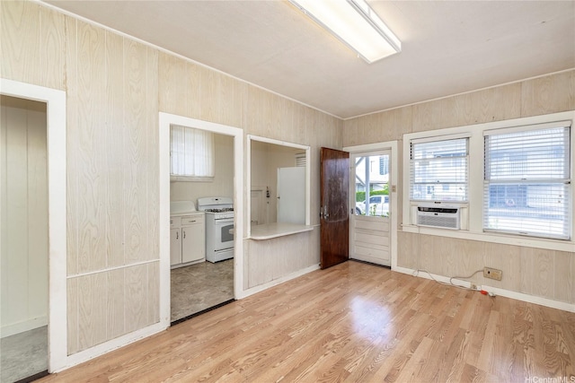 spare room with light wood-style floors, baseboards, and cooling unit