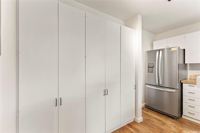 46-130 Kiowai St Unit 2724, Kaneohe, HI 96744 - kitchen featuring stainless steel refrigerator with ice dispenser, light wood-type flooring, light countertops, baseboards, and white cabinets