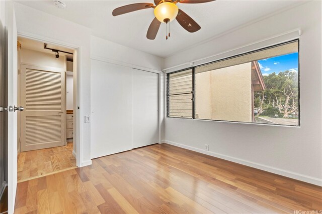 46-130 Kiowai St Unit 2724, Kaneohe, HI 96744 - unfurnished bedroom featuring baseboards, ceiling fan, wood finished floors, and a closet