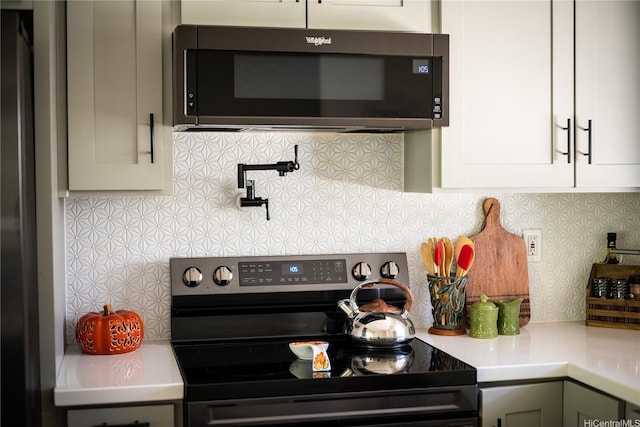 94-1081 Anania Cir Unit 12, Mililani, HI 96789 - kitchen with stainless steel electric range oven, white cabinetry, decorative backsplash, and light countertops