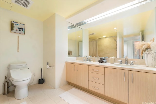 full bath featuring tile patterned flooring, a tile shower, toilet, and double vanity