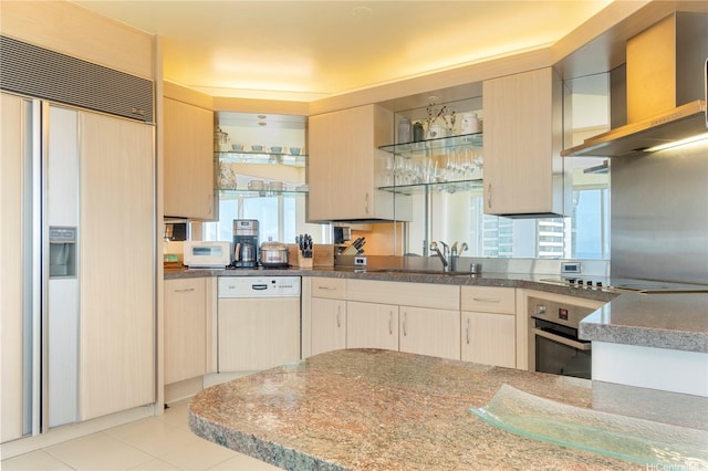 kitchen with paneled appliances, a sink, open shelves, and plenty of natural light