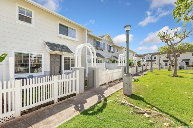 91-1031 Kaimalie St Unit 4B2, Ewa Beach, HI 96706 - view of front facade with roof with shingles, fence, a front lawn, and a residential view