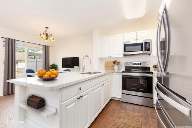 91-1031 Kaimalie St Unit 4B2, Ewa Beach, HI 96706 - kitchen with a sink, a peninsula, an inviting chandelier, white cabinets, and appliances with stainless steel finishes