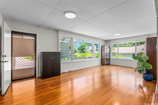 unfurnished room with light wood finished floors and a decorative wall