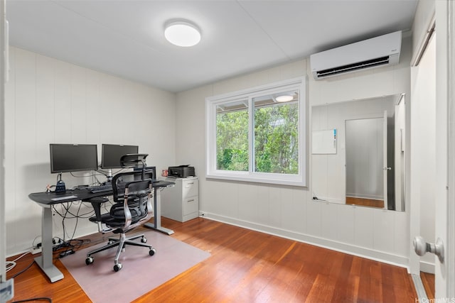 office space featuring a wall unit AC, wood finished floors, and baseboards