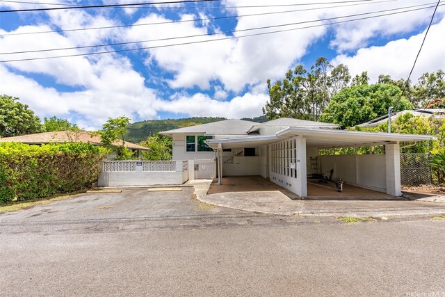 view of front facade with fence, a gate, and a carport