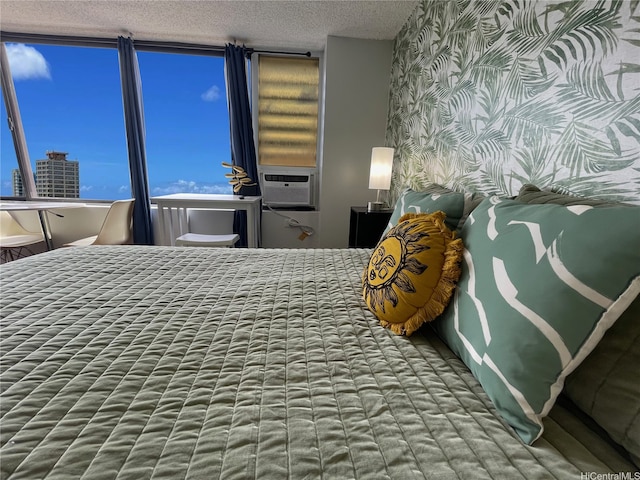bedroom featuring a textured ceiling, wallpapered walls, and cooling unit