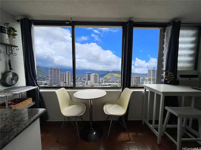 dining room with a view of city, dark wood-style flooring, and a wealth of natural light