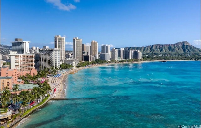exterior space with a water and mountain view, a view of city, and a view of the beach