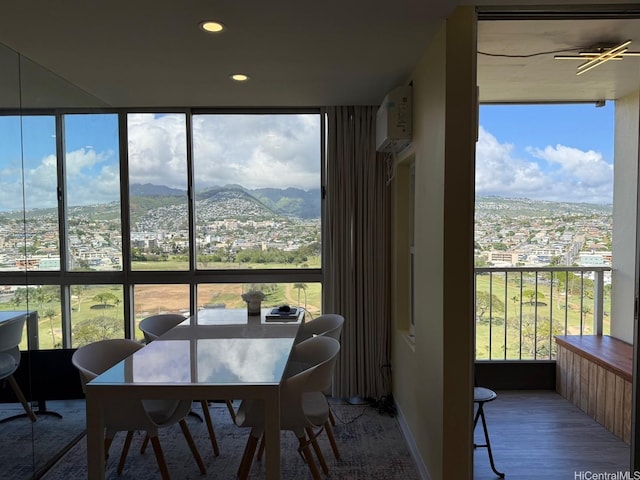 sunroom / solarium featuring a mountain view and a wall mounted air conditioner