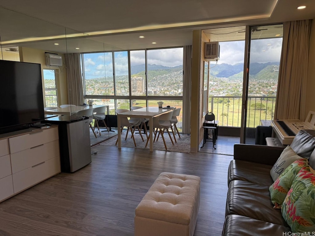 living area featuring a wall of windows, a mountain view, and wood finished floors