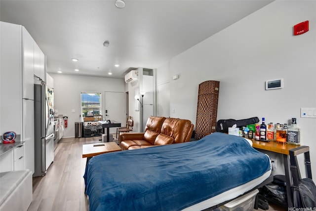 bedroom with freestanding refrigerator, recessed lighting, light wood finished floors, and an AC wall unit