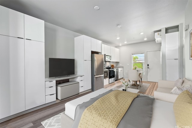 interior space with freestanding refrigerator, light wood finished floors, and recessed lighting