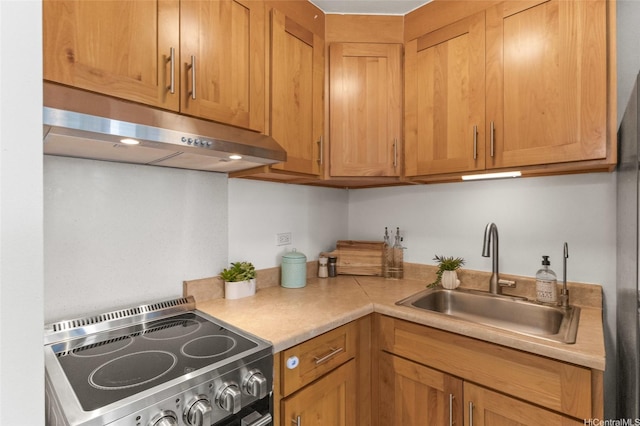 kitchen with a sink, light countertops, under cabinet range hood, and stainless steel range with electric cooktop