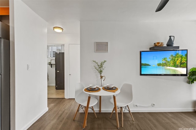 dining area with baseboards and wood finished floors