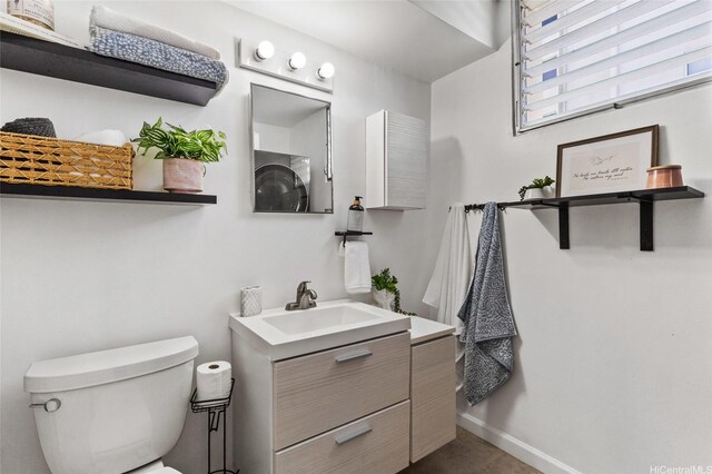 bathroom featuring vanity, baseboards, and toilet