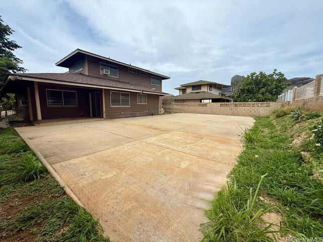 back of house featuring a patio, fence, and driveway