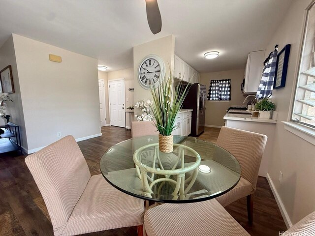 dining room featuring a ceiling fan, baseboards, and dark wood-type flooring