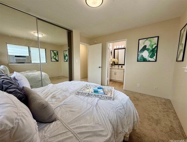 bedroom featuring light carpet, a closet, ensuite bath, and cooling unit