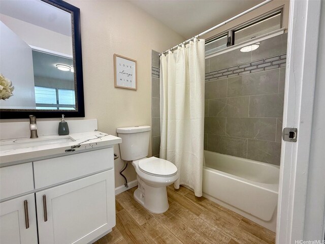bathroom with vanity, shower / bathtub combination with curtain, toilet, and wood finished floors