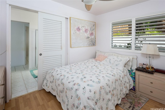 bedroom with a ceiling fan, light wood finished floors, and a closet