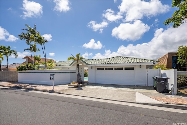 single story home featuring driveway, fence, a garage, stucco siding, and a tile roof