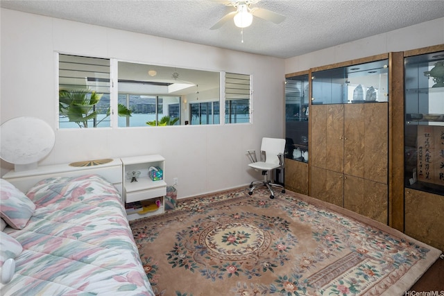 bedroom featuring ceiling fan and a textured ceiling
