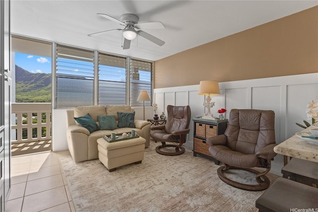 tiled living room with a healthy amount of sunlight, a decorative wall, and ceiling fan
