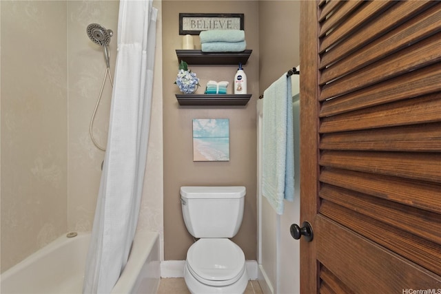 bathroom with toilet, baseboards, and shower / bath combo