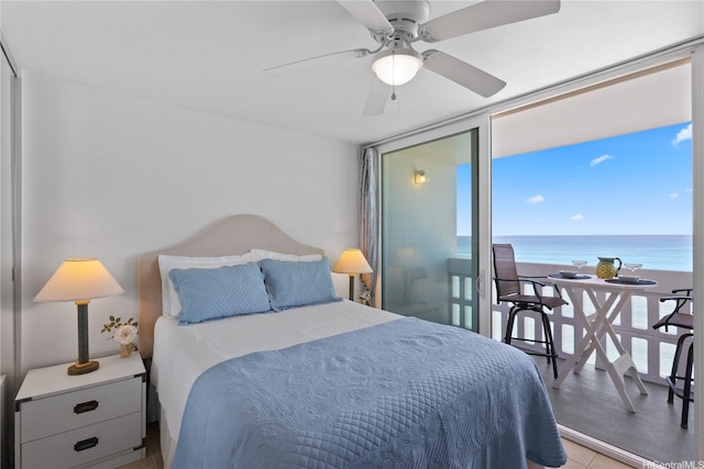 bedroom featuring multiple windows, a water view, and a ceiling fan
