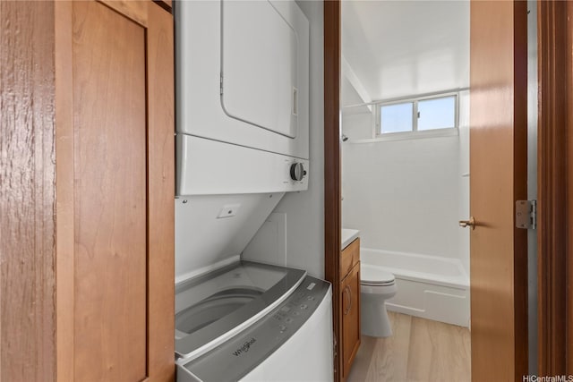 laundry area featuring light wood-style floors and stacked washer and clothes dryer