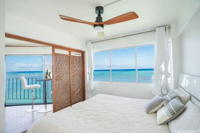 bedroom featuring a water view and a ceiling fan