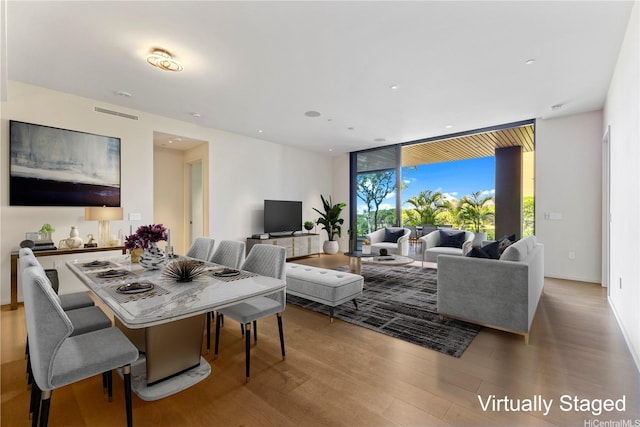living room featuring recessed lighting, floor to ceiling windows, wood finished floors, and visible vents