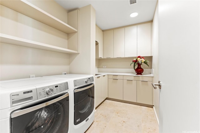 washroom featuring separate washer and dryer, cabinet space, and visible vents
