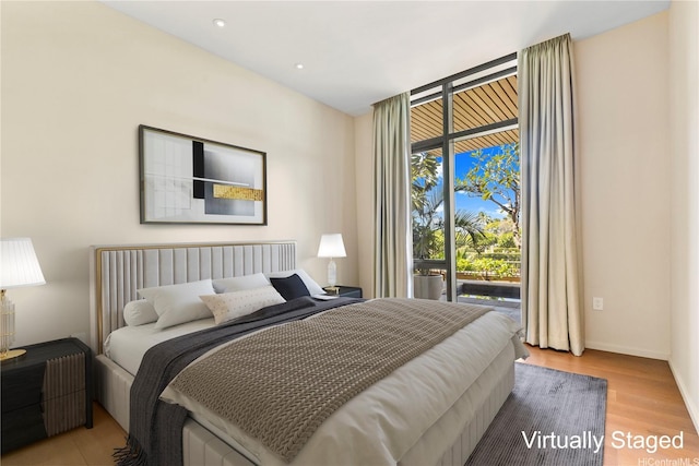 bedroom featuring recessed lighting, baseboards, access to exterior, and wood finished floors